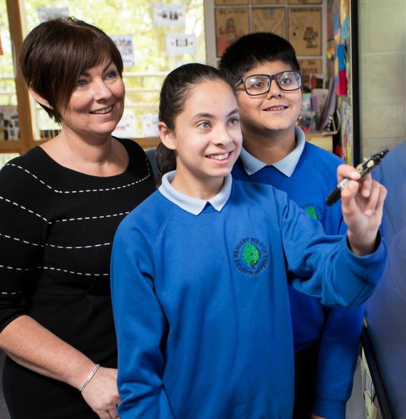 photo of teacher with 2 students at whiteboard