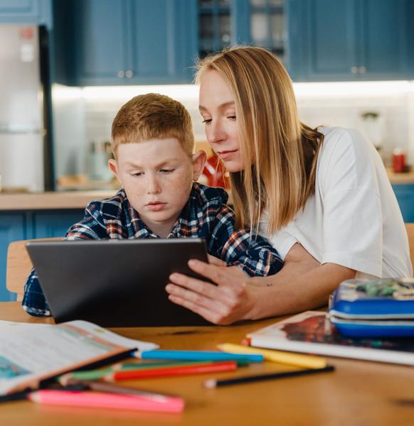 A parent helping their son with their homework